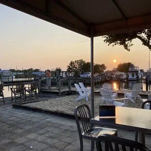 tables and chairs on a patio overlooking the water