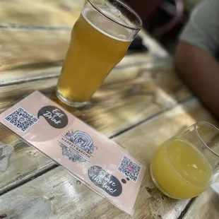 a glass of beer and a ticket on a wooden table