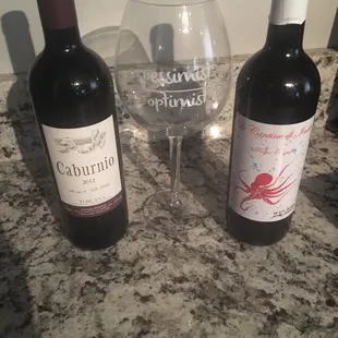 two bottles of wine and a glass of wine