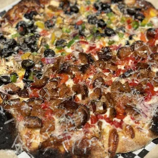 a whole pizza on a checkered paper plate