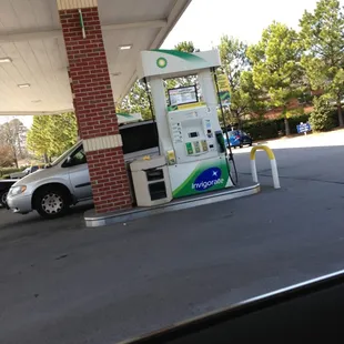 a gas station with a car at the pump