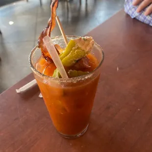 a bloody drink with bacon and pickles