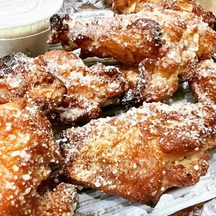 a pile of fried doughnuts with powdered sugar on top