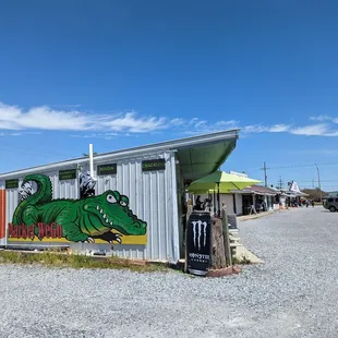 a green alligator painted on the side of a building
