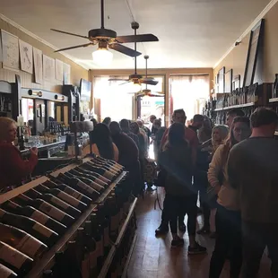 a large group of people in a wine shop