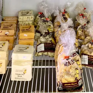 a variety of cheeses in a refrigerator