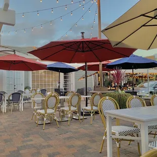 tables and chairs with umbrellas