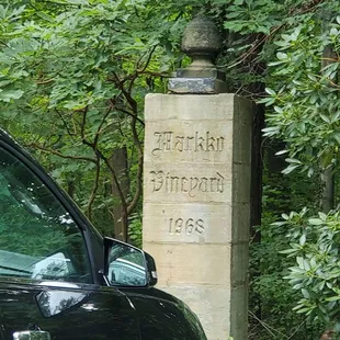 a black car parked in front of a stone monument