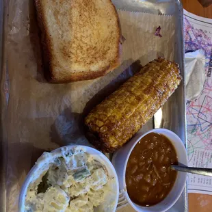 Veggie plate with red potato salad, fried corn on the cob, and baked beans