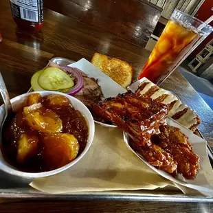 a tray of food including ribs and sides