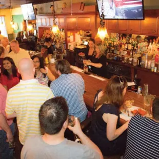 a crowd of people sitting at a bar