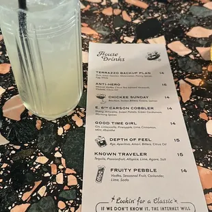 a menu and a drink on a table