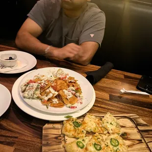 a man sitting at a table with plates of food