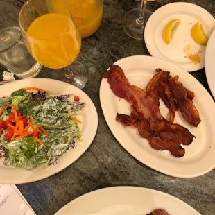 Mixed green salad and bacon on the side