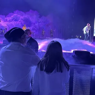 a man and a woman standing in front of a stage