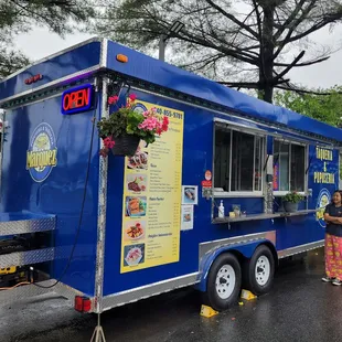 a woman standing in front of a food truck