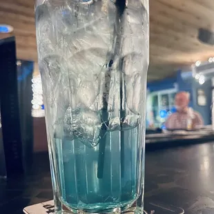 a glass of water with ice and a straw