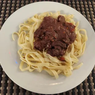 a plate of beef and noodles
