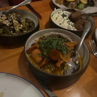 a variety of dishes of food on a wooden table