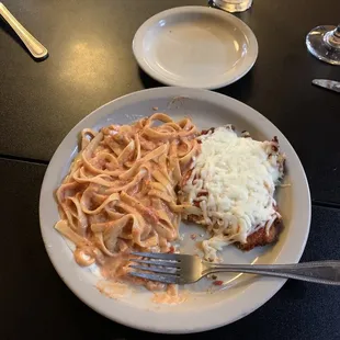 Chicken parmigiana and pasta with tomato cream sauce.