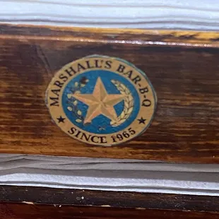 Crest on napkin and condiment holder.