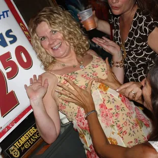 a woman in a floral dress with her hands in the air