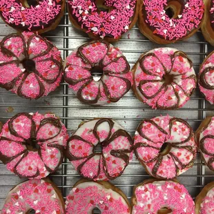 a variety of pink and white sprinkle donuts