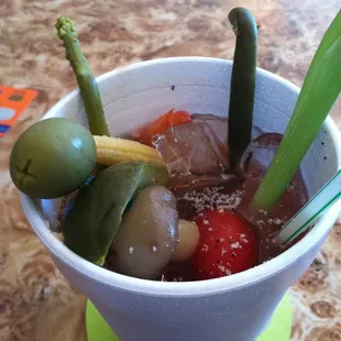 a cup of soup with vegetables and olives