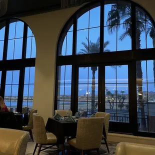 a dining room with large windows overlooking the ocean