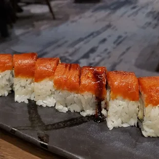 a sushi roll on a slate platter