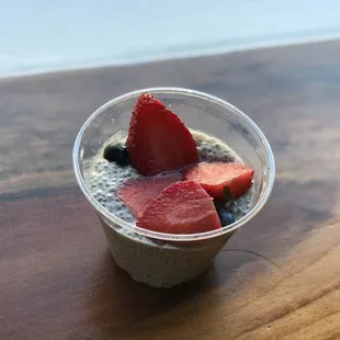 a cup of chia pudding with strawberries and blueberries