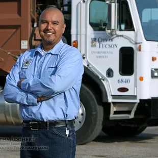 Advertising/ PR photo: COT Environmental Services employee by the sanitation truck he drives.