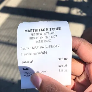 a hand holding a receipt