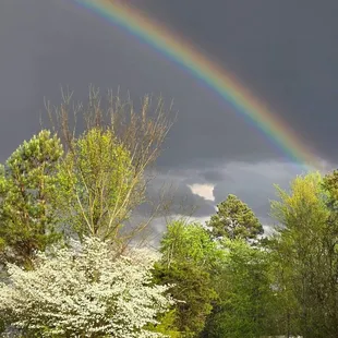 Local storm clouds and a double rainbow .