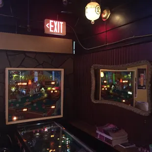 a pinball table and exit sign