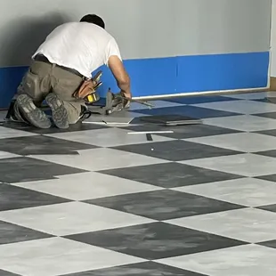 a man working on a checkered floor
