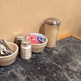 two bowls of utensils and a salt and pepper shaker