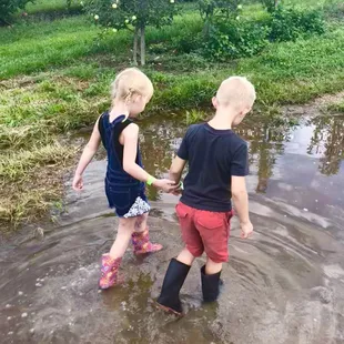 two children playing in a puddle