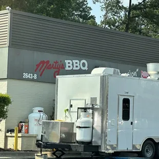 a white food truck parked in front of a building