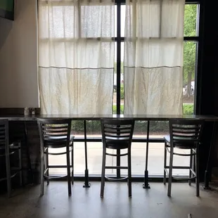 Bar seating inside the restaurant by the window.