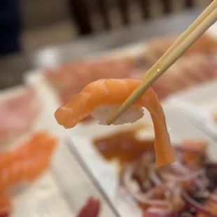 a close up of a sushi with chopsticks