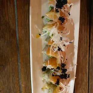 a long rectangular plate of food on a wooden table