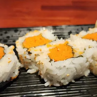 a close up of sushi rolls on a black plate