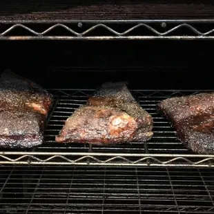 three steaks cooking in an oven