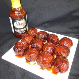 a plate of meatballs and a bottle of sauce