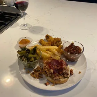 Pulled pork bbq sandwich, lemon wings, baked beans, collard greens, fries, and a little cornbread to top it off. Delish and local!!