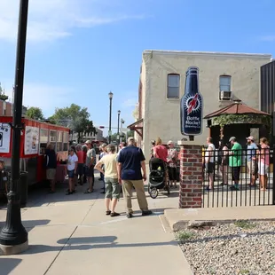 a crowd of people walking down a sidewalk