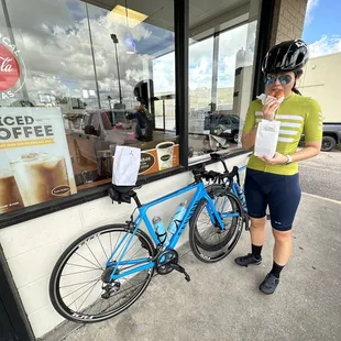 a woman standing next to a bicycle