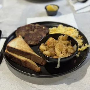Potatoes, toast, scrambled eggs, and turkey sausage