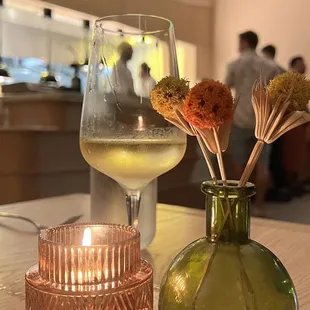 a glass of wine and a vase of flowers